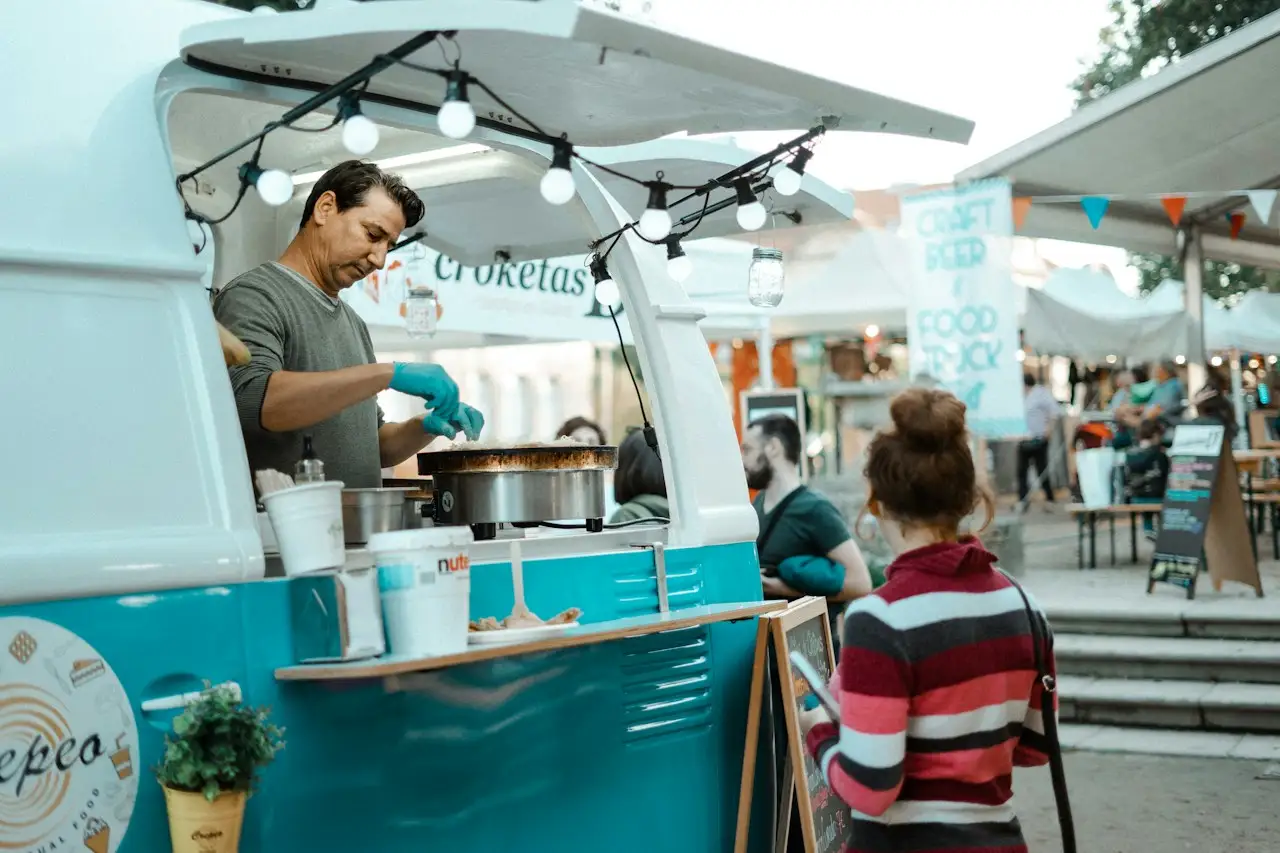 Koch in einem Food-Truck bereitet Essen für Gäste auf einem Straßenfest zu